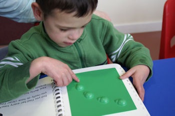 A child touching a tactile book